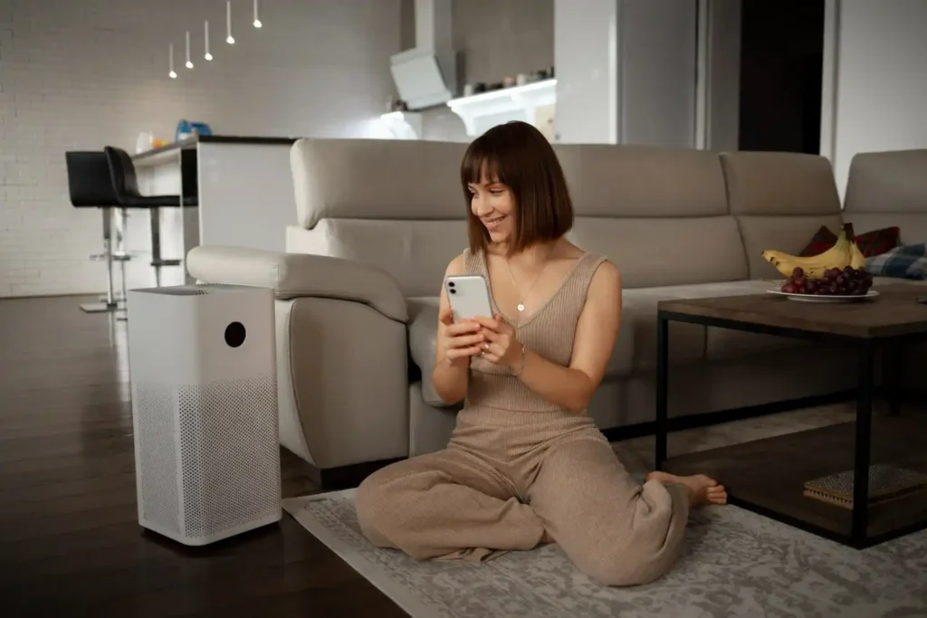 Donna che utilizza un dispositivo smart home, evidenziando la comodità e la funzionalità nella vita quotidiana.