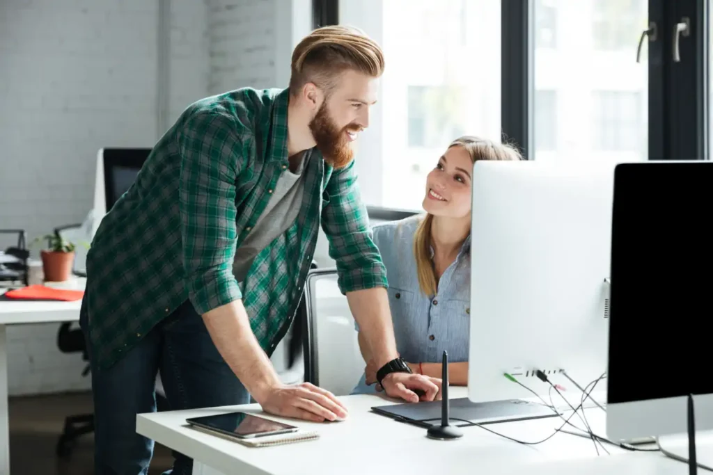 Sviluppatori siti web di Volta: Gli sviluppatori di Volta Next Generations lavorano concentrati davanti a un computer, con un ambiente moderno e tecnologico, scrivendo codici su un monitor multiplo.