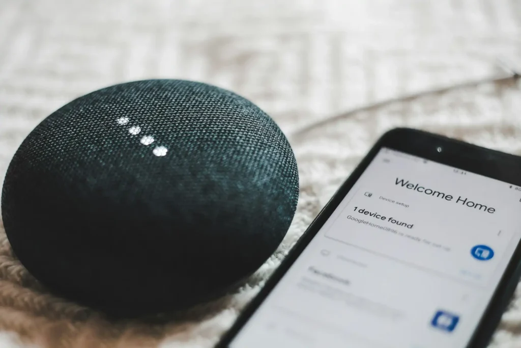 Un dispositivo Alexa Echo posizionato su un tavolo in un soggiorno moderno, con una luce LED blu che segnala l'attivazione del sistema vocale, circondato da decorazioni eleganti.